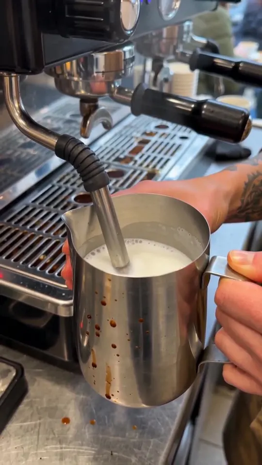 Kadr z filmu AI: Baristka i stały klient, dwa zdania po polsku, mżawka za szybą.